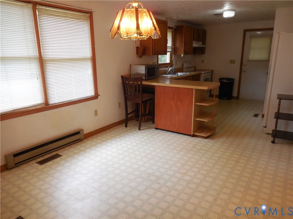 6185 Parrish Road, Louisa, VA 23093 Kitchen with wood-finish cabinetry, built-in breakfast bar with shelving, and double windows