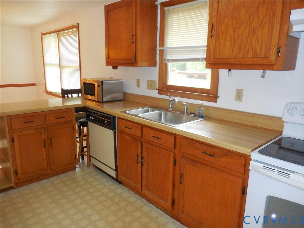 6185 Parrish Road, Louisa, VA 23093 Wood-finish cabinetry, double basin stainless steel sink, integrated dishwasher, and white electric range