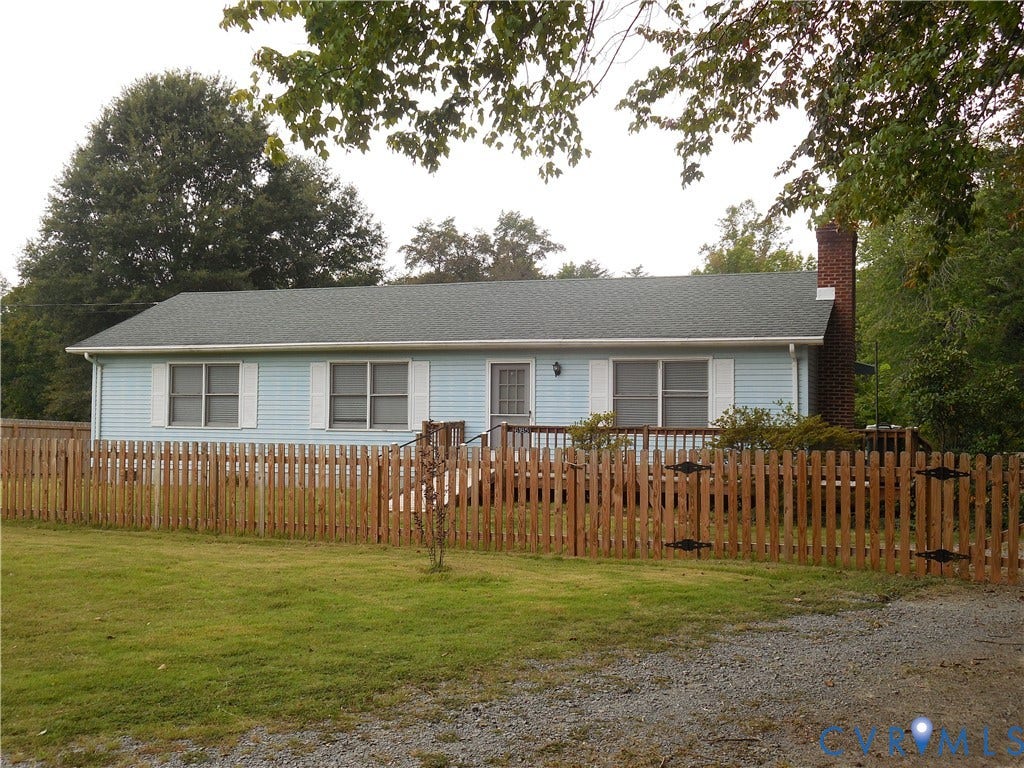6185 Parrish Road, Louisa, VA 23093 Light blue siding, dark roof, wooden picket fence, brick chimney, gravel driveway
