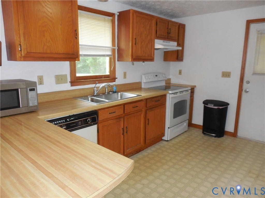 6185 Parrish Road, Louisa, VA 23093 Wood-finish cabinetry, stainless steel sink, built-in dishwasher, and white electric range