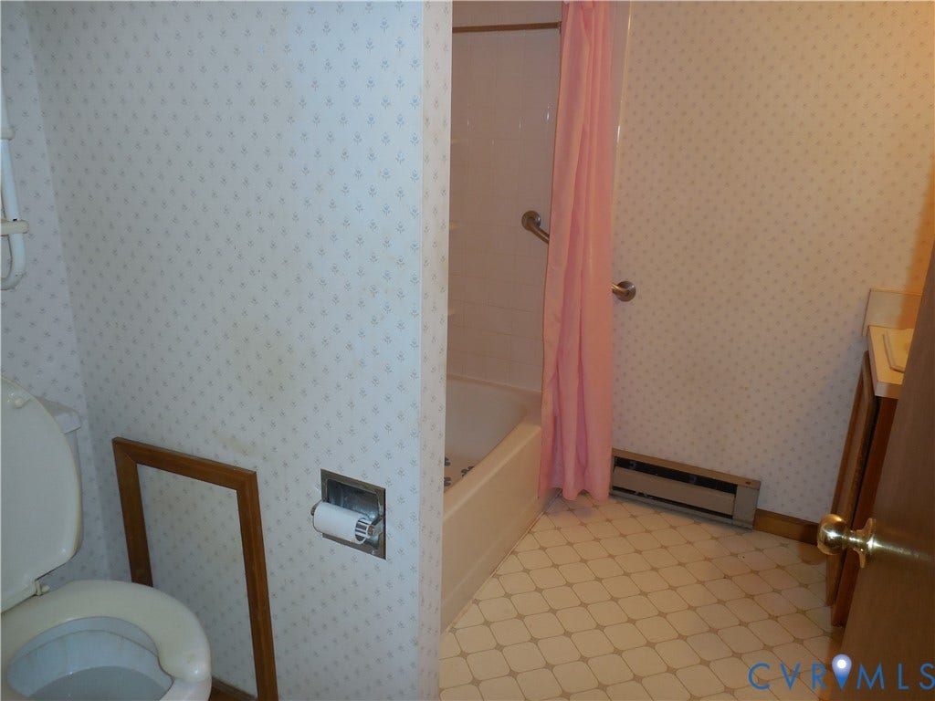 6185 Parrish Road, Louisa, VA 23093 White ceramic tile flooring, built-in bathtub with grab bar, built-in vanity, and patterned wall covering