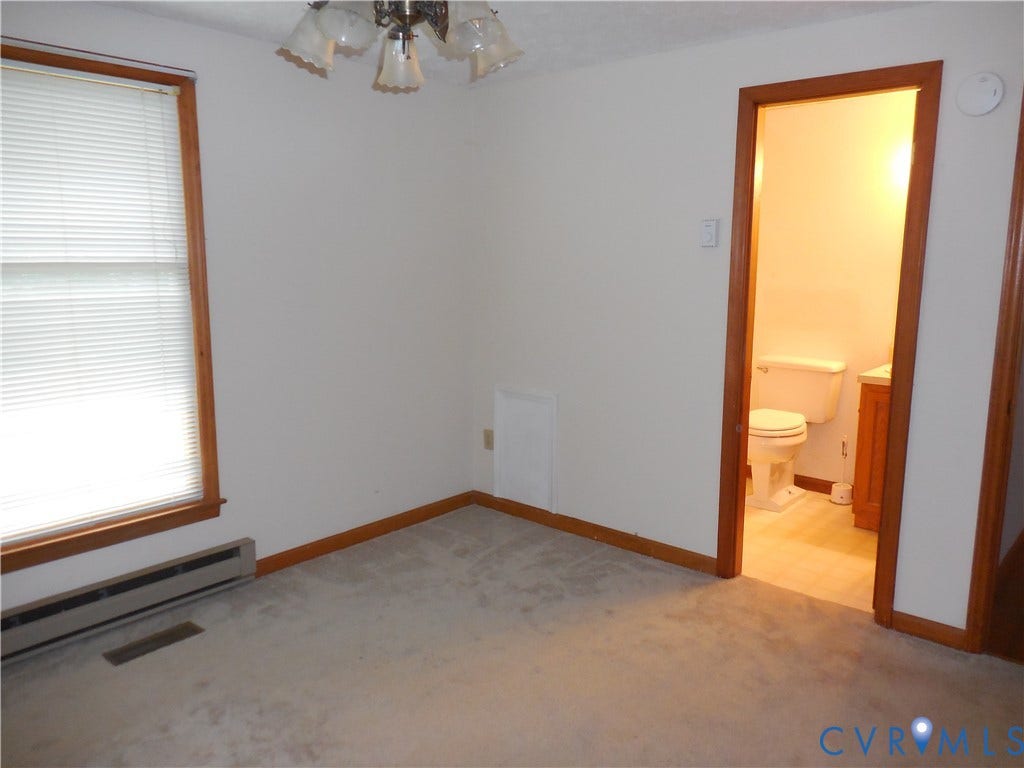 6185 Parrish Road, Louisa, VA 23093 Carpeted room featuring a window with wood trim, a ceiling-mounted light fixture, and a white baseboard heater