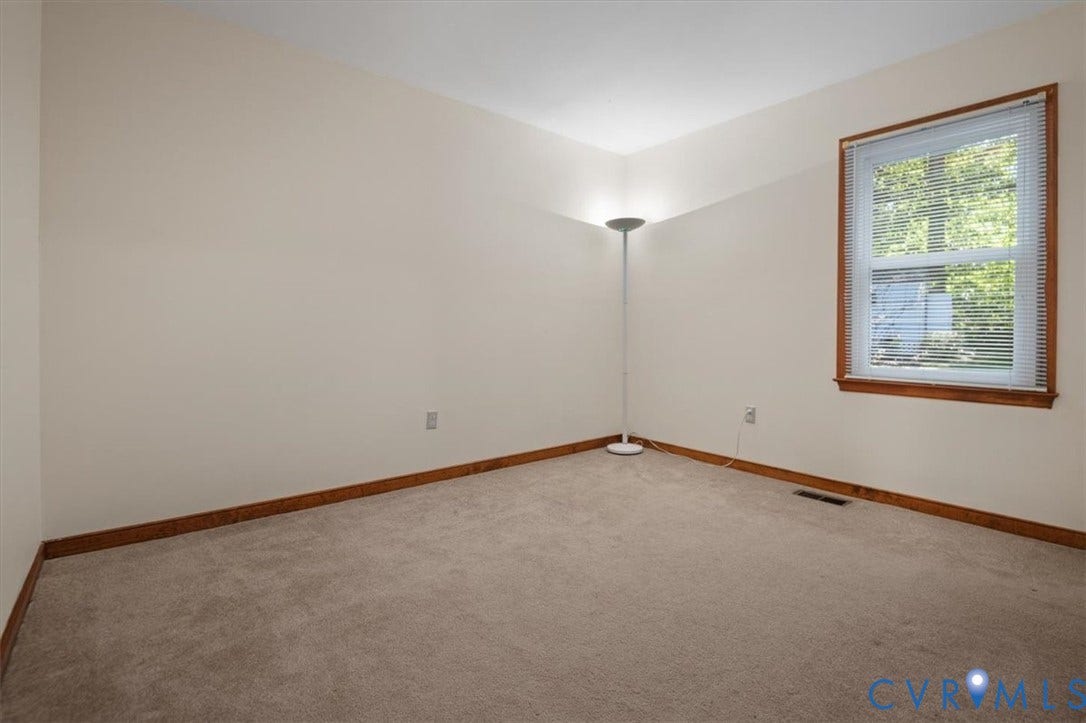 Neutral wall tones with a window featuring horizontal blinds