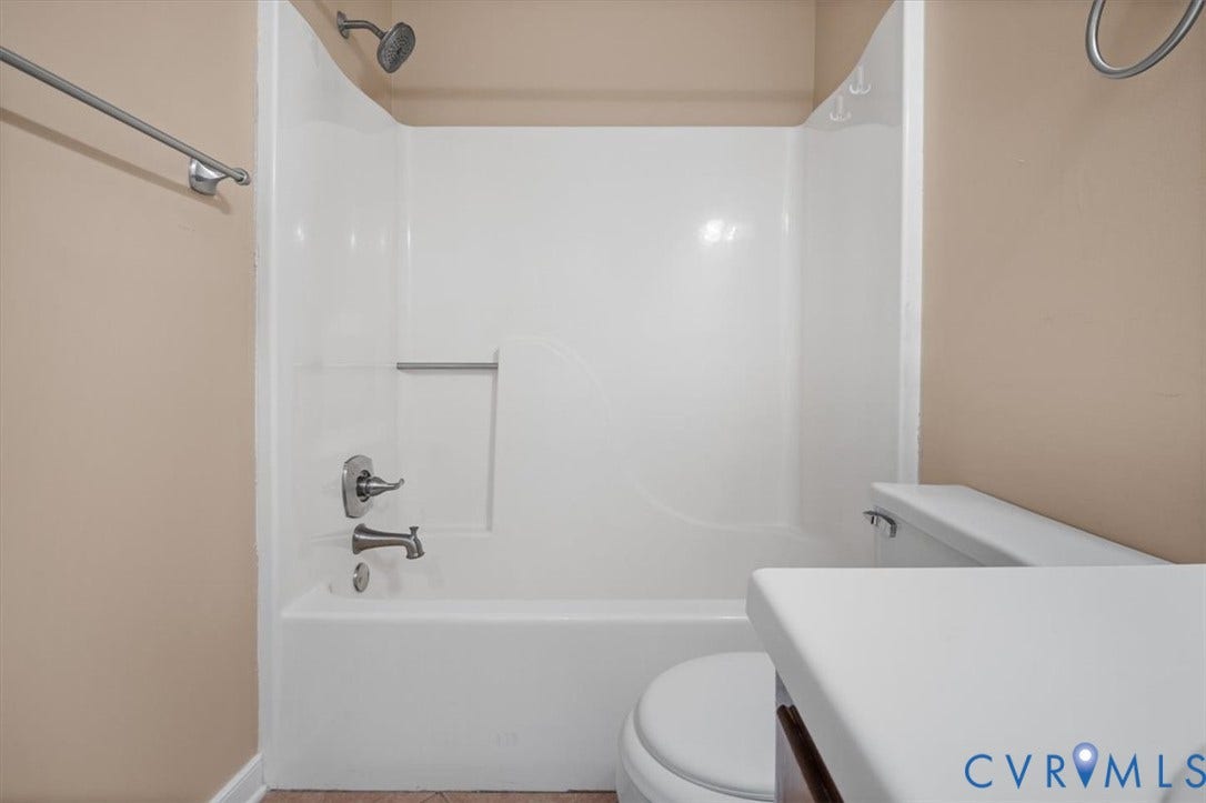 White acrylic tub and shower combination with chrome fixtures