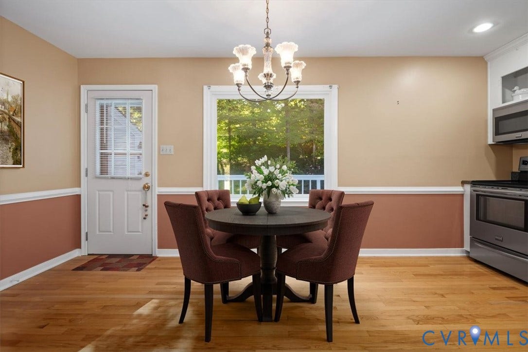 Hardwood flooring, chair rail molding, large window with natural light, glass-paneled exterior door, stainless steel range with microwave