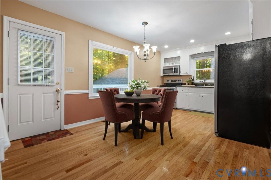 Hardwood flooring, recessed lighting, white cabinetry, stainless steel appliances, and a built-in kitchen sink