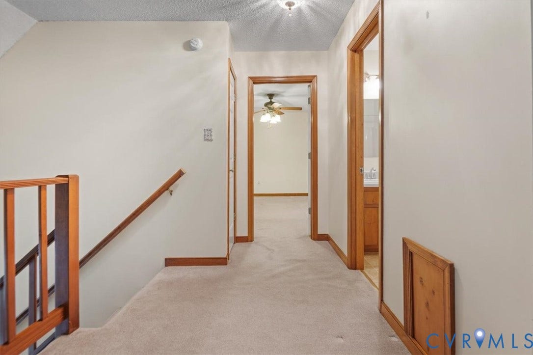 Carpeted hallway with wood-finish trim and doors