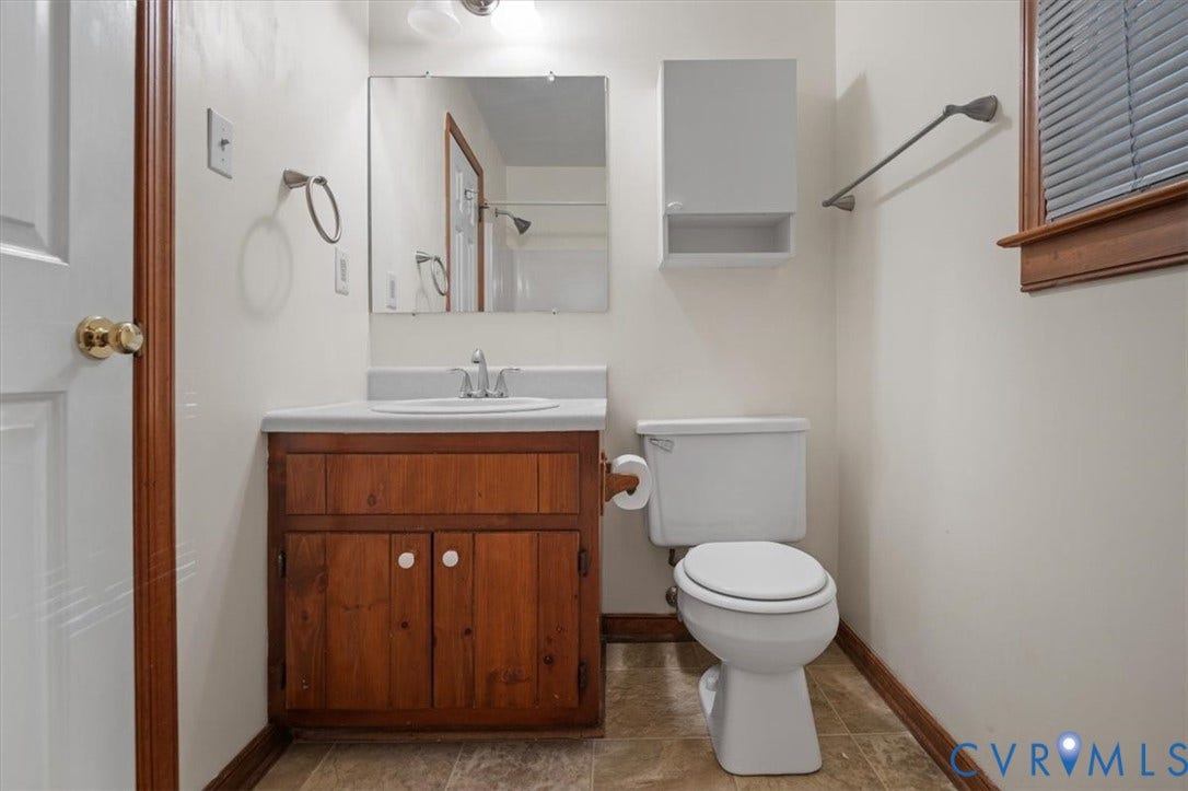 Wood-finish vanity with an integrated sink and chrome faucet, accompanied by a wall-mounted medicine cabinet