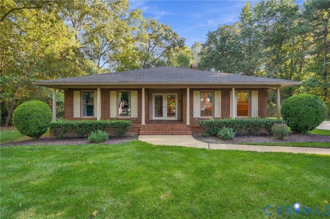 Brick exterior with a covered front porch and a dark shingle roof
