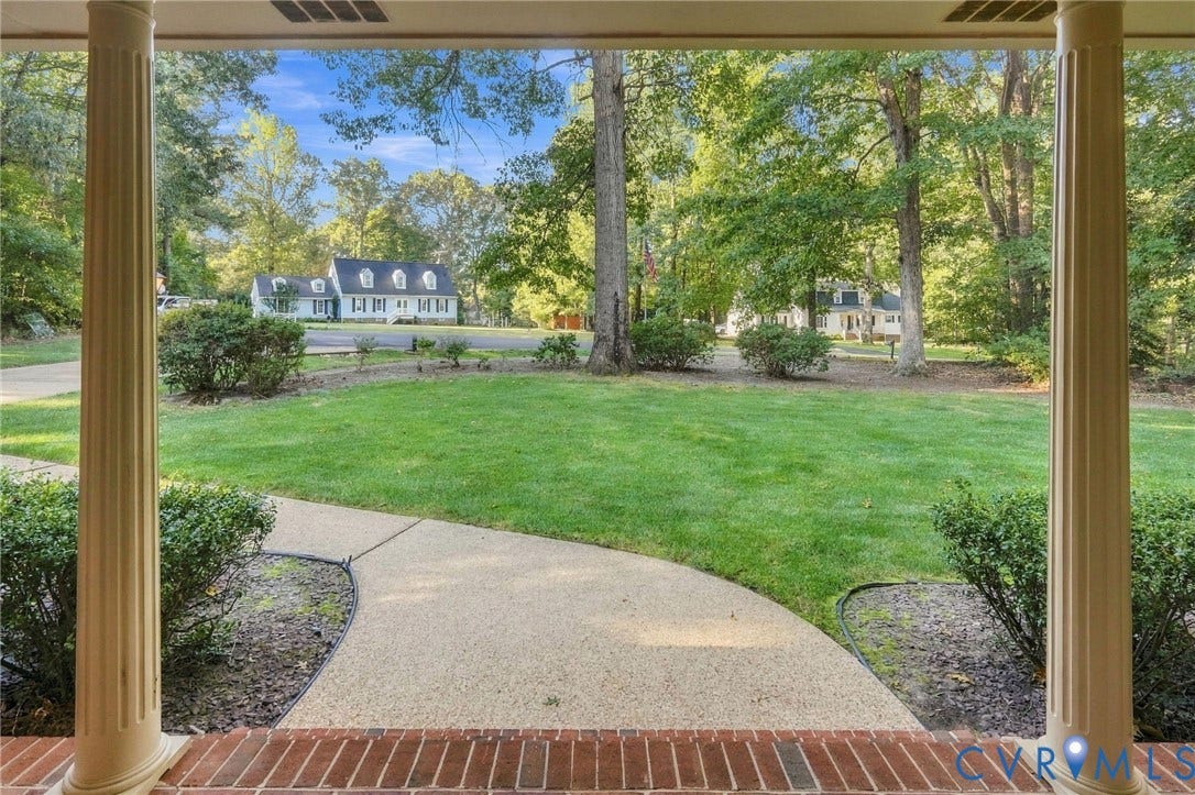 Entry with brick flooring and fluted columns