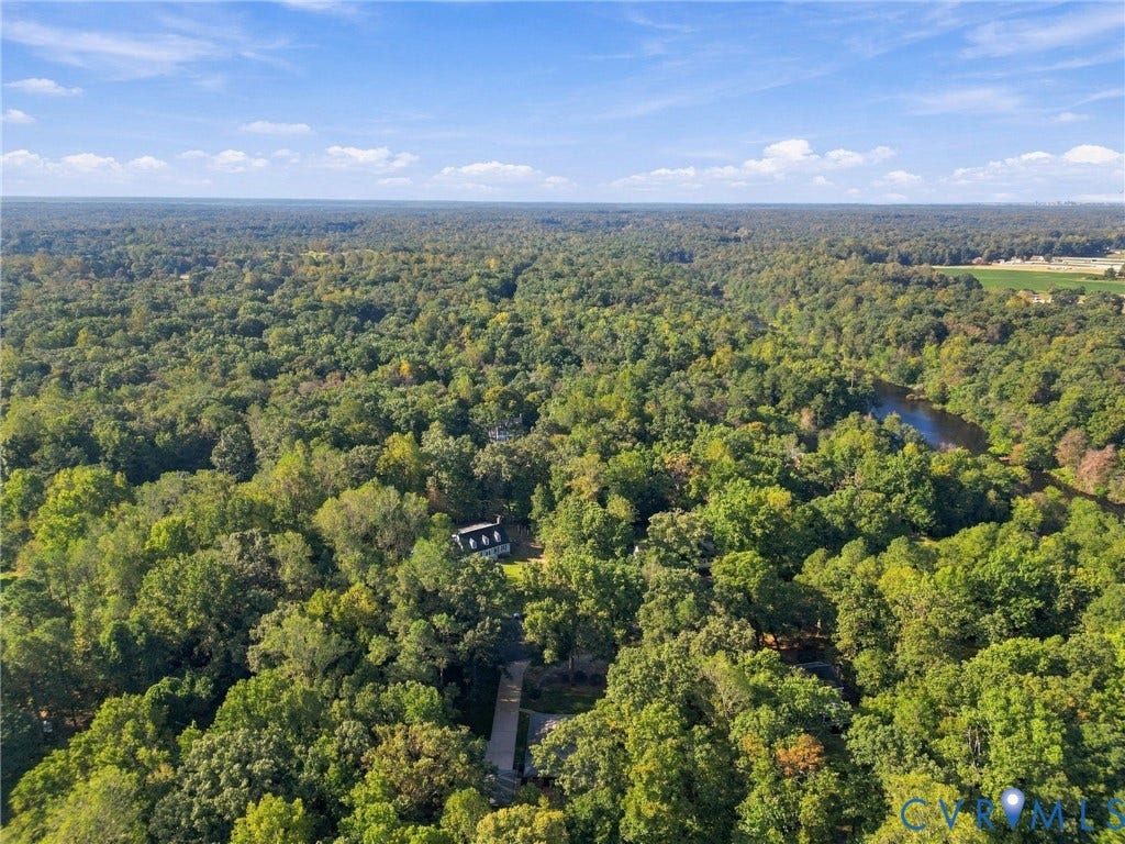 Expansive wooded property featuring a natural body of water