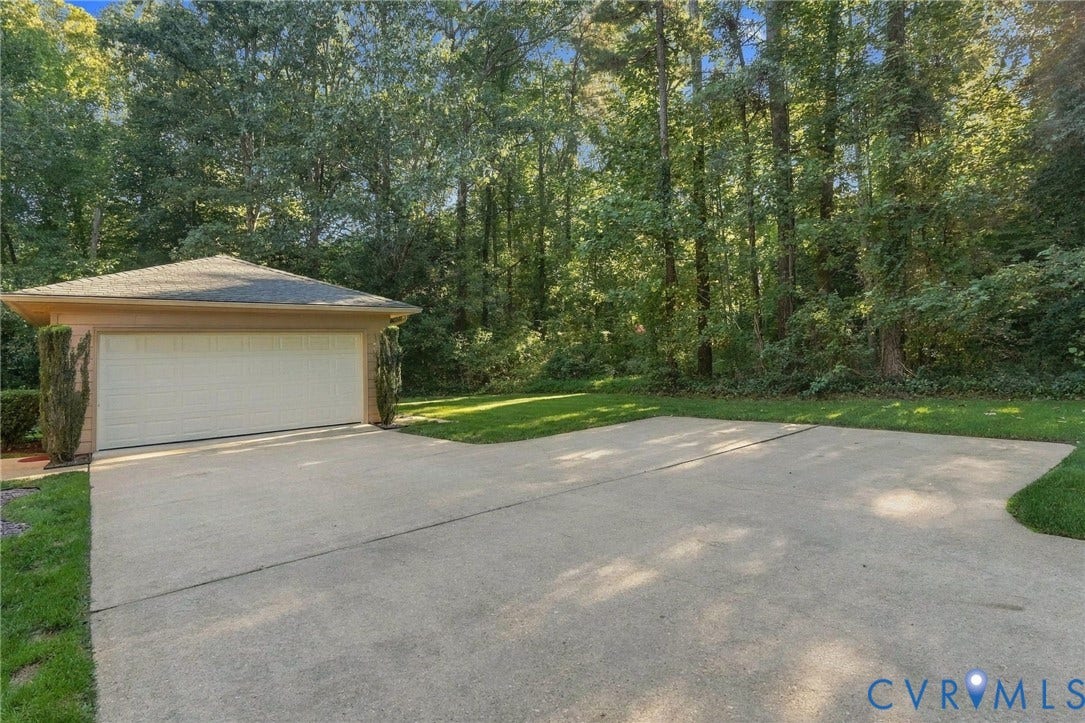 Attached garage with a single vehicle door and concrete driveway