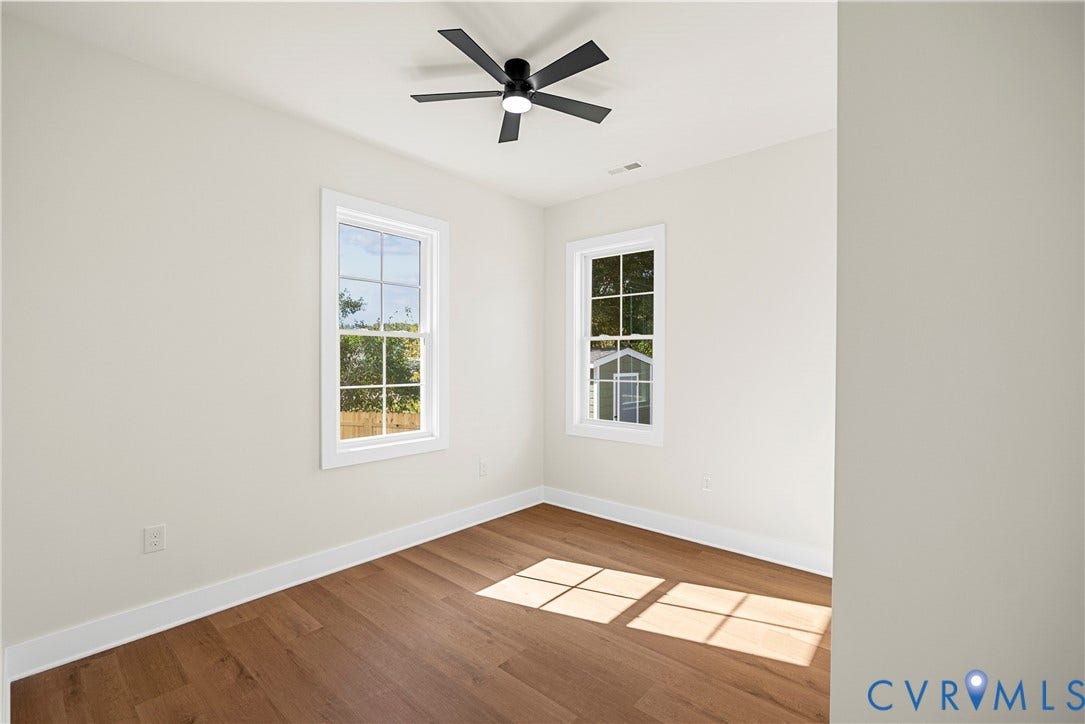 Wood-finish flooring, white trim, and two paneled windows with white frames