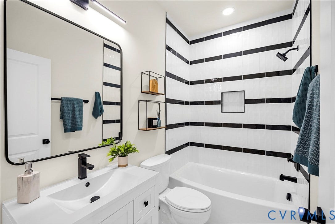 White vanity with integrated sink, matte black faucet, and rectangular mirror