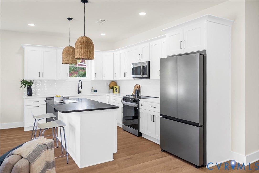 Modern kitchen featuring white shaker cabinetry, stainless steel appliances, a center island with a dark countertop, and wood-finish flooring