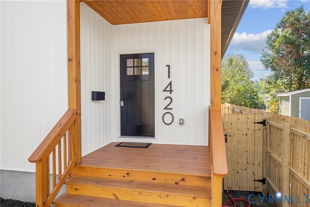 Front porch featuring natural wood stairs, porch floor, and railing