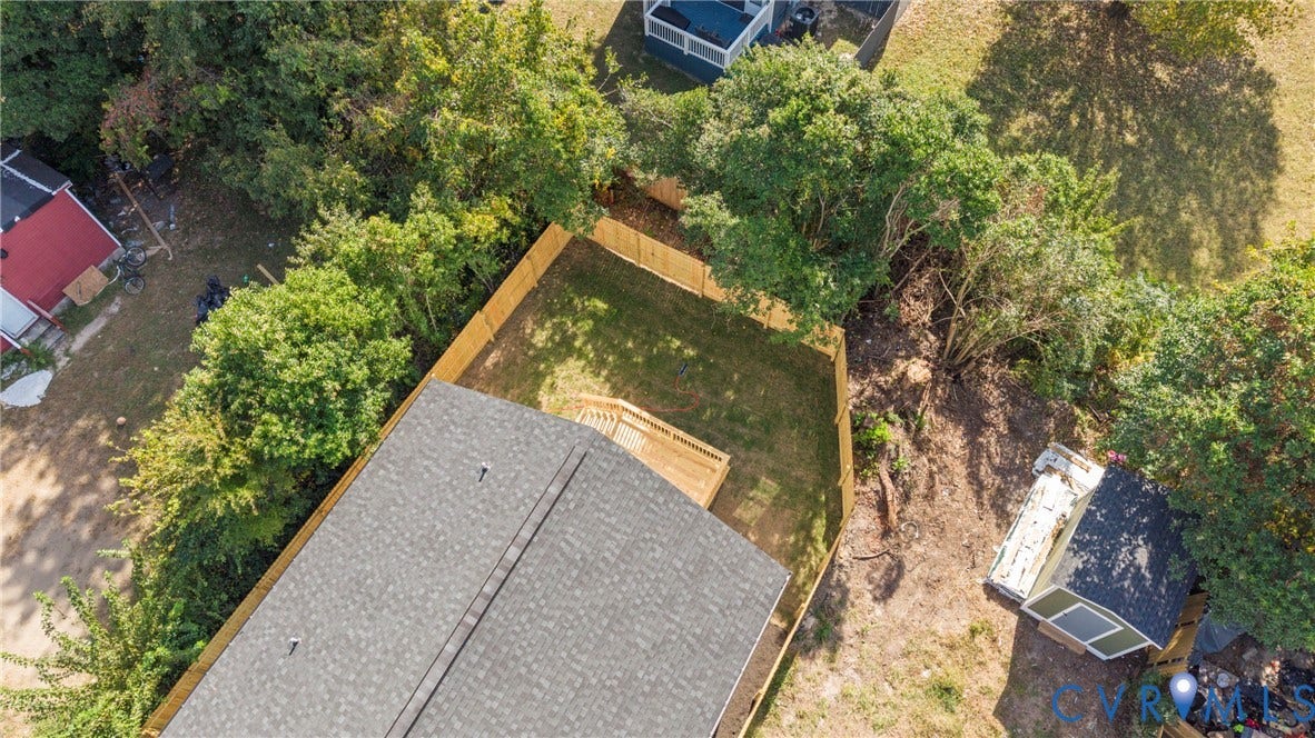 Rear yard with wooden privacy fencing, a wood deck, and a detached storage shed