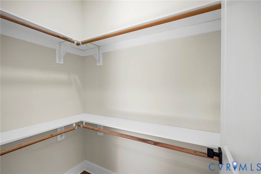 Built-in shelving and hanging rods with neutral wall tones
