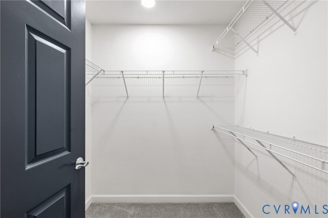 4820 Old Main Street, #301, Henrico, VA 23231 Walk-in closet #1. Recessed ceiling light illuminating a closet with white wire shelving, grey carpet, and a dark paneled door with a brushed nickel handle