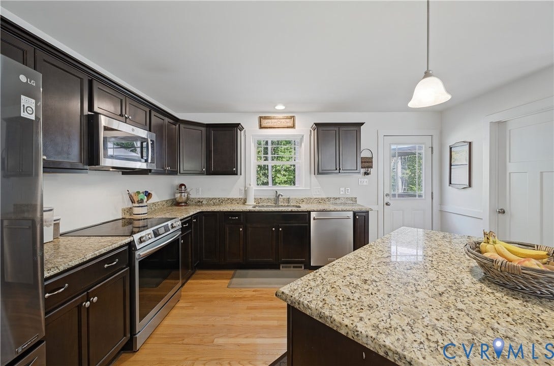 700 Manchester Road, Louisa, VA 23024 Kitchen featuring wood-finish flooring, dark wood cabinetry, light-toned countertops, and stainless steel appliances