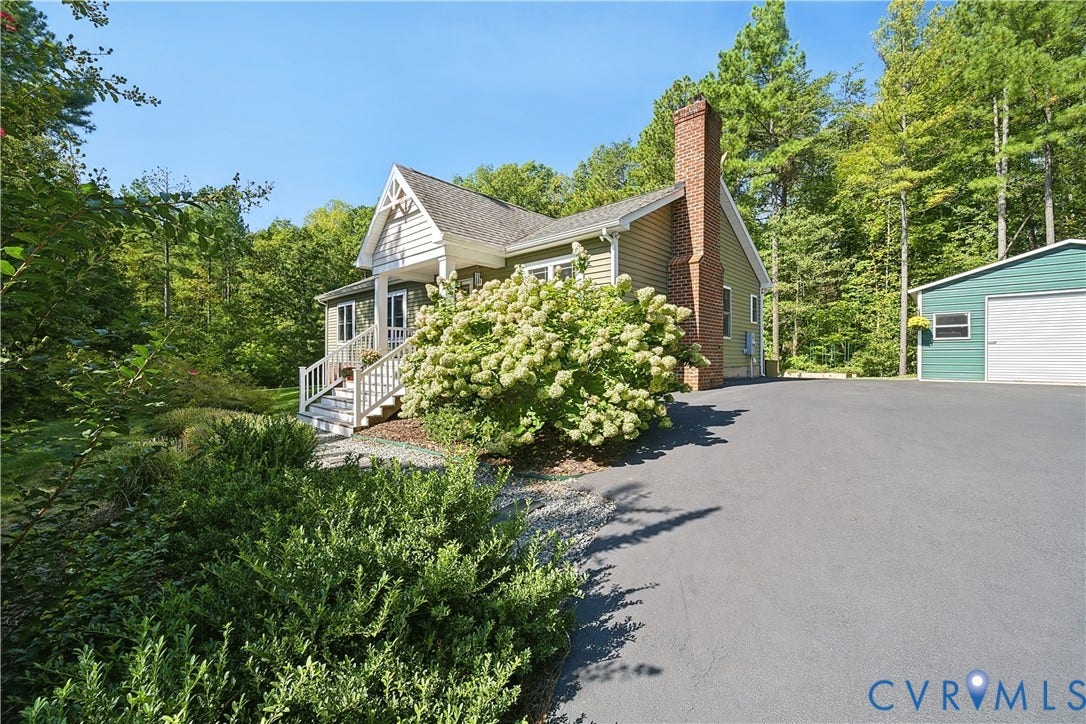 700 Manchester Road, Louisa, VA 23024 Siding exterior with a prominent brick chimney, asphalt driveway, and detached garage