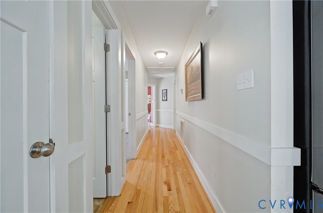 700 Manchester Road, Louisa, VA 23024 Hallway featuring wood-finish flooring, white paneled doors, and wainscoting
