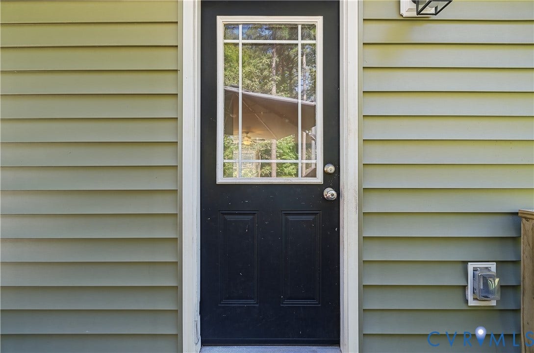 700 Manchester Road, Louisa, VA 23024 Green horizontal siding with a black paneled door featuring decorative lites