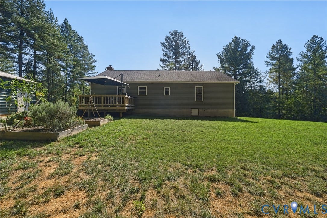 700 Manchester Road, Louisa, VA 23024 Expansive backyard featuring a wood deck, wood siding, and mature trees