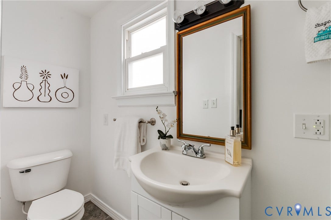 2224 Seminary Avenue, Richmond, VA 23220 Pedestal sink with chrome faucet, framed mirror with integrated lighting, and a white toilet