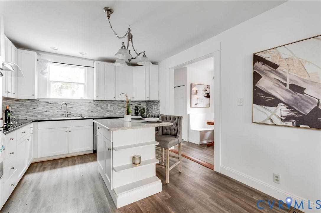 2224 Seminary Avenue, Richmond, VA 23220 Kitchen featuring white shaker cabinetry, an island with countertop seating, stainless steel sink, tile backsplash, and wood-finish flooring