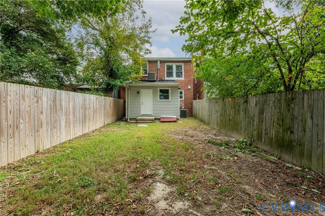 2224 Seminary Avenue, Richmond, VA 23220 Fenced backyard featuring a wood fence, established trees, and a ground-level door