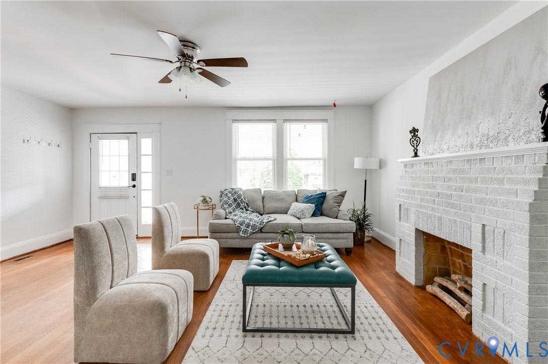 2224 Seminary Avenue, Richmond, VA 23220 Hardwood flooring, painted brick fireplace with mantel, ceiling fan with integrated lighting, glass-paneled door, and bright window