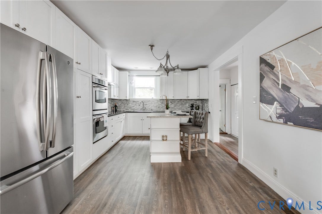 2224 Seminary Avenue, Richmond, VA 23220 Kitchen featuring wood-finish flooring, white cabinetry, stainless steel appliances, a center island, and a tiled backsplash