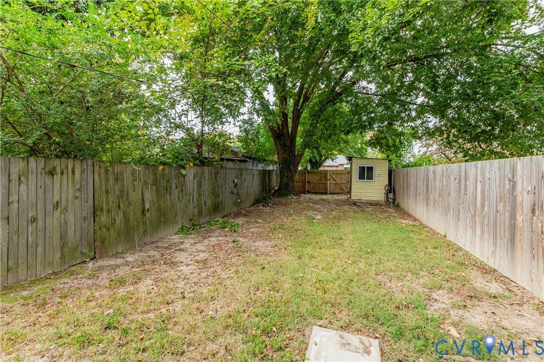 2224 Seminary Avenue, Richmond, VA 23220 Fenced backyard featuring a mature tree and a detached shed with a window