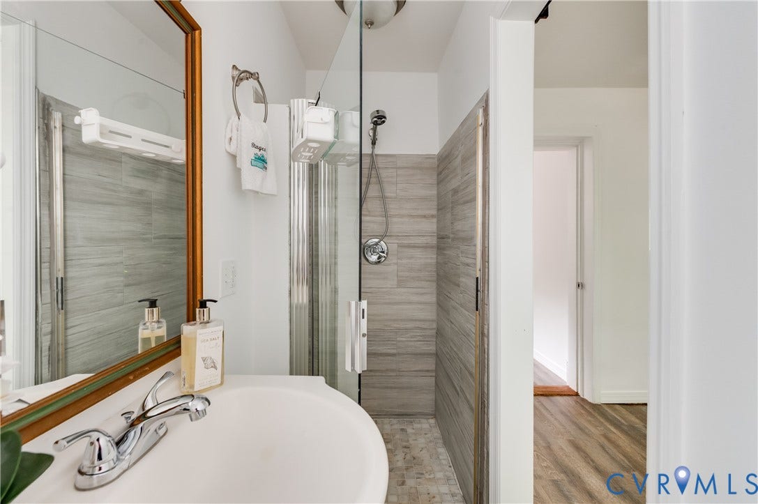 2224 Seminary Avenue, Richmond, VA 23220 Walk-in shower with glass enclosure and tiled walls, chrome shower fixtures, and a white basin sink with chrome faucet