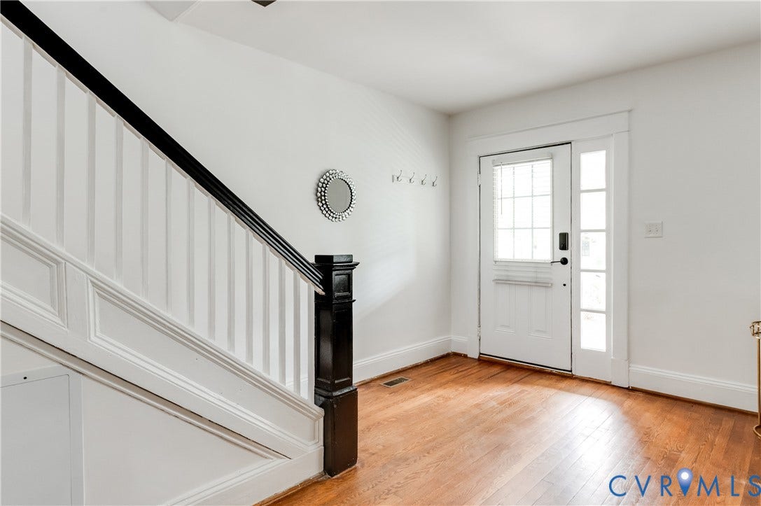 2224 Seminary Avenue, Richmond, VA 23220 Hardwood flooring, painted white walls, black handrail, white balusters, and a front entry door with a sidelight