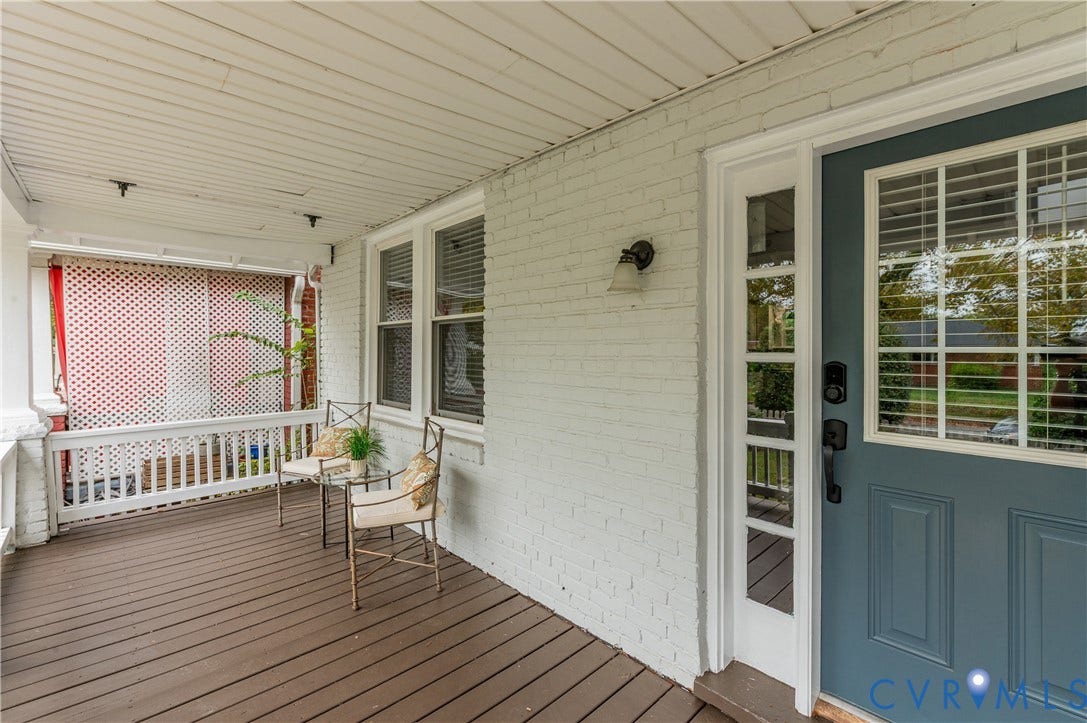 2224 Seminary Avenue, Richmond, VA 23220 Covered porch with wood-finish decking, white brick exterior, multi-pane windows, and a panel door with sidelights