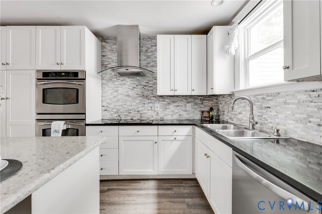 2224 Seminary Avenue, Richmond, VA 23220 White shaker cabinetry, stainless steel appliances, dark countertops, a tiled backsplash, and wood-finish flooring