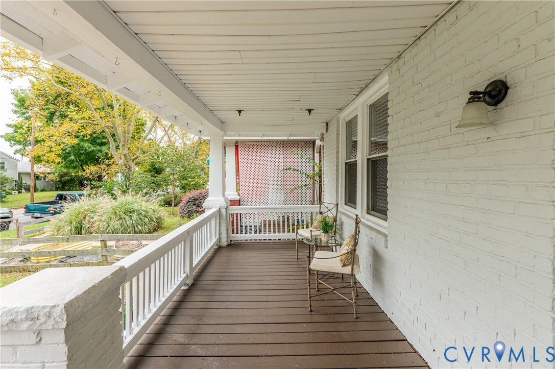 2224 Seminary Avenue, Richmond, VA 23220 Covered front porch featuring wood-finish decking, white brick exterior, and a white baluster railing