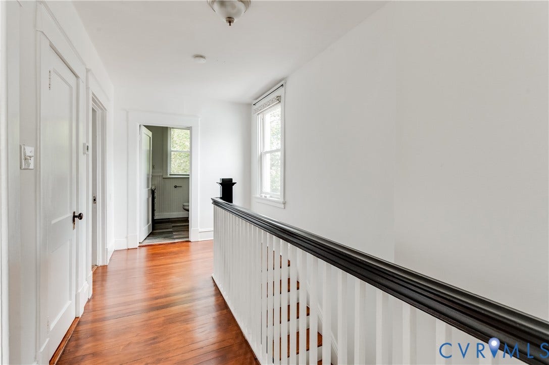 2224 Seminary Avenue, Richmond, VA 23220 Hardwood flooring, painted white walls, white trim, and a staircase with a dark wood-finish handrail and white balusters