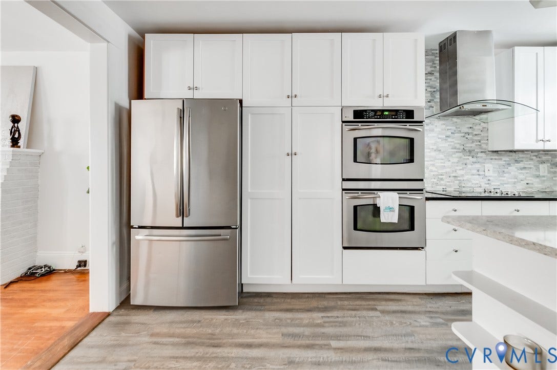 2224 Seminary Avenue, Richmond, VA 23220 White cabinetry, stainless steel French door refrigerator, built-in double ovens, tile backsplash, and wood-finish flooring