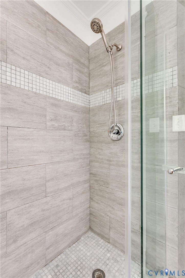 2224 Seminary Avenue, Richmond, VA 23220 Glass-enclosed shower with a brushed nickel shower head, large format wall tiles, and a mosaic tile floor