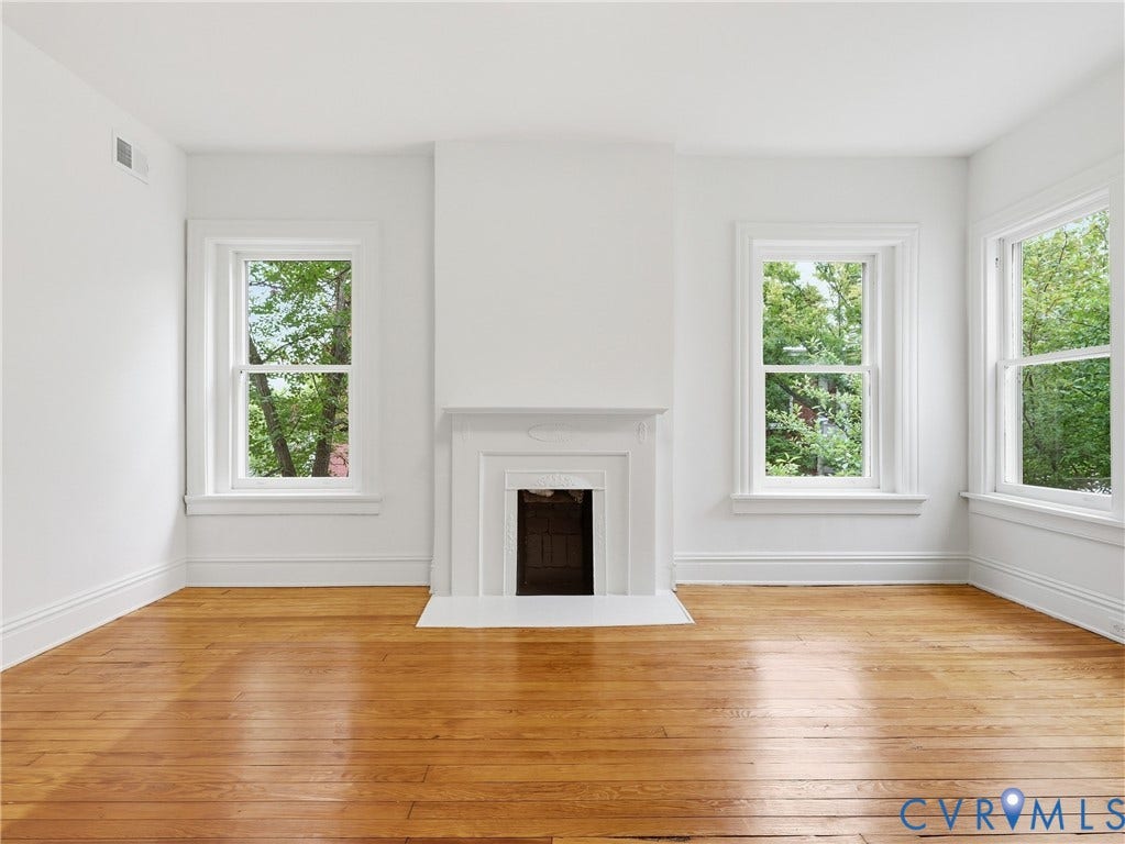 1901 Hanover Avenue, Fan, Richmond, VA 23220 Hardwood flooring, three sash windows, white trim, and a decorative fireplace