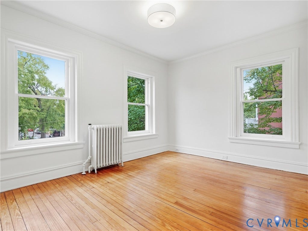 1901 Hanover Avenue, Fan, Richmond, VA 23220 Light wood-finish flooring, three windows with white trim, white walls, and a ceiling-mounted light fixture