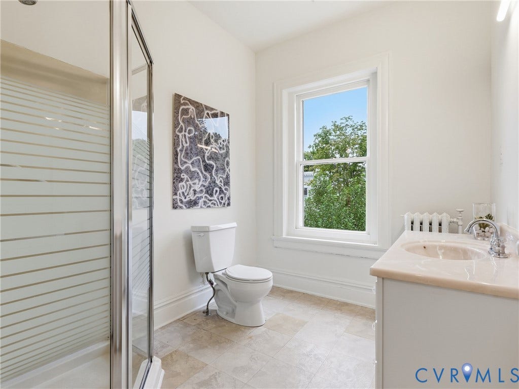 1901 Hanover Avenue, Fan, Richmond, VA 23220 Shower enclosure with frosted glass, white vanity with integrated sink, chrome faucet, window with white trim, and tile flooring