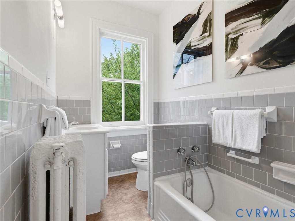 1901 Hanover Avenue, Fan, Richmond, VA 23220 Bathroom with white subway tile and gray square tile wainscoting, featuring a built-in bathtub with chrome fixtures, a window, and a white pedestal sink