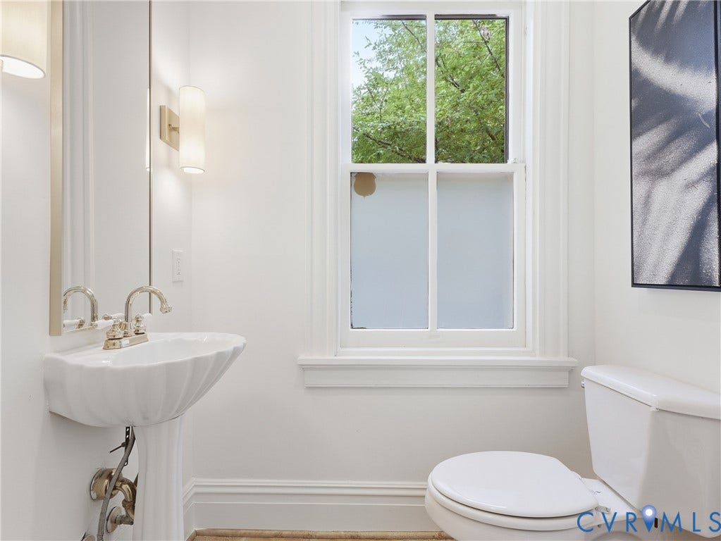 1901 Hanover Avenue, Fan, Richmond, VA 23220 Pedestal sink with polished nickel faucet, wall-mounted sconce lighting, and a white framed window