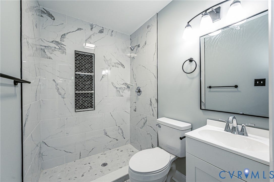 1724 Alaska Drive, Richmond, VA 23224 Walk-in shower with large format marble-look tile walls and a built-in mosaic tile niche