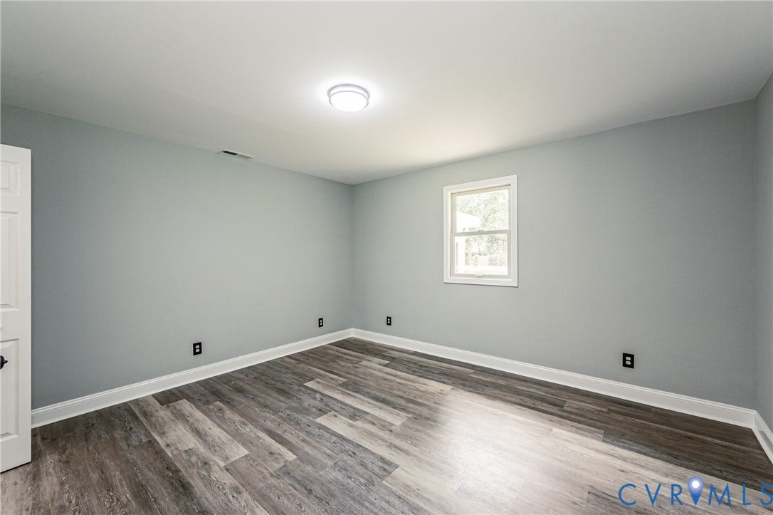 1724 Alaska Drive, Richmond, VA 23224 Wood-finish flooring, light gray walls, white trim, and a window with white casing