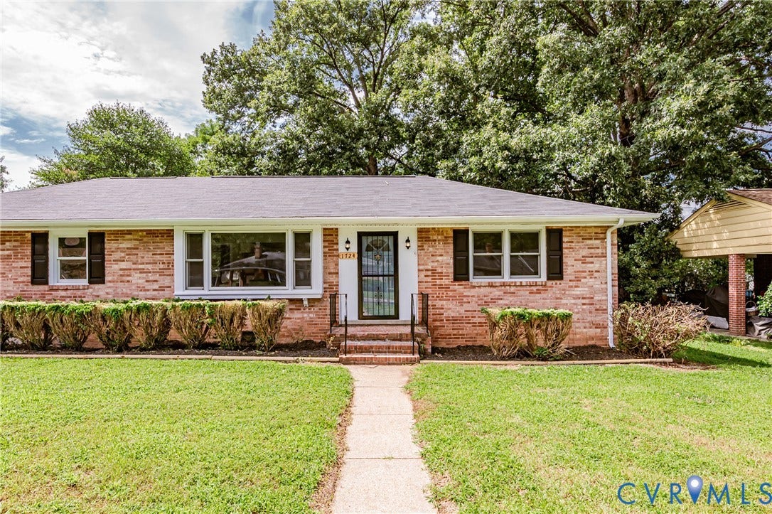 1724 Alaska Drive, Richmond, VA 23224 Brick exterior with multiple windows, a concrete walkway, and a covered entry